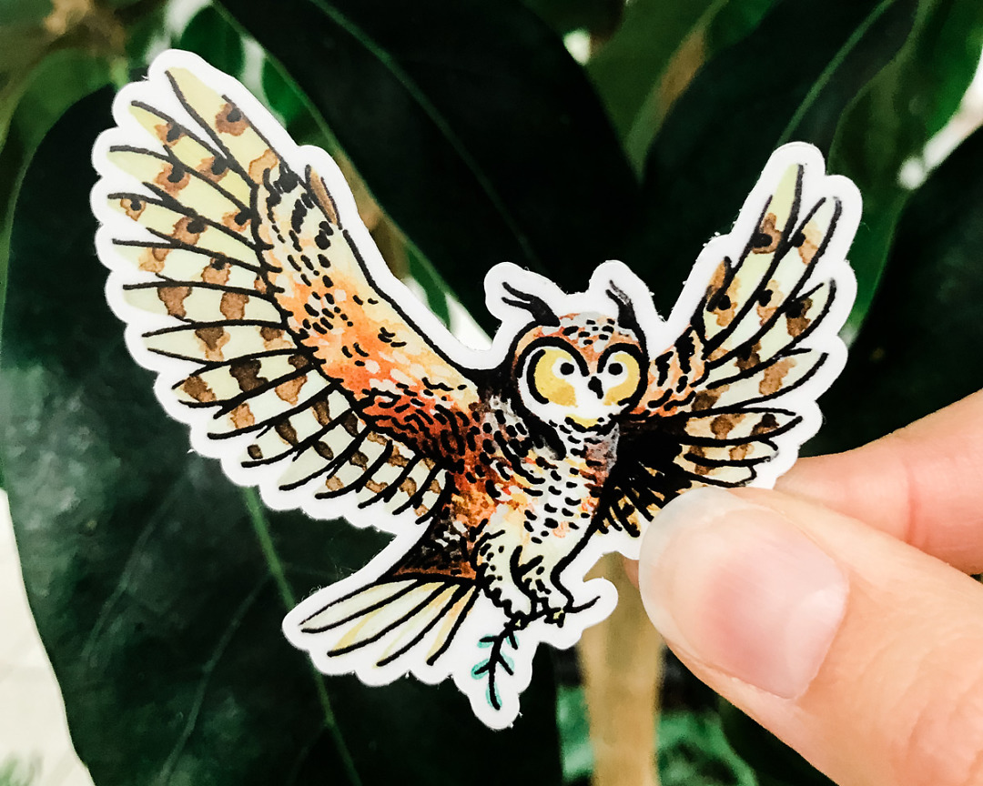cute owl vinyl animal sticker art by wildship studio held against plants