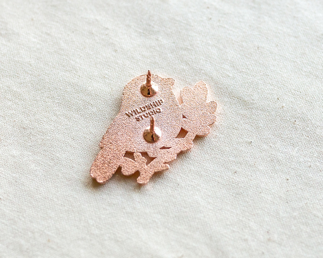 the backside of copper chickadee enamel pin