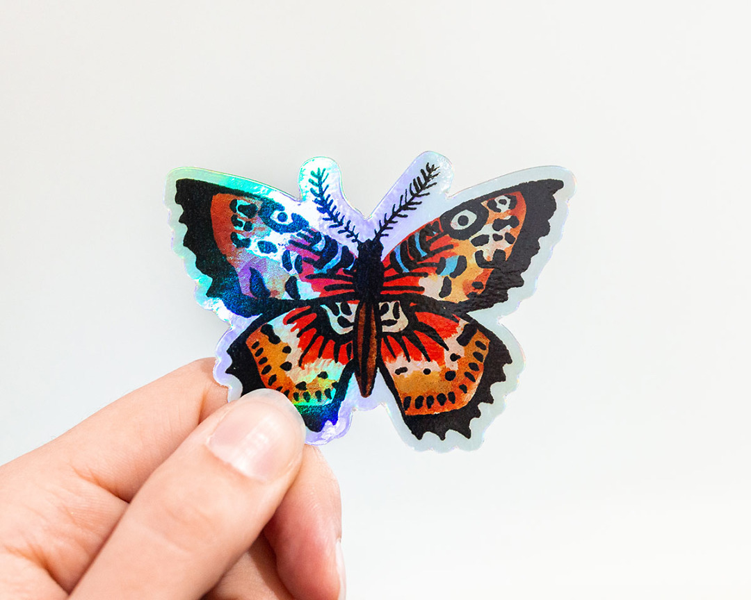 hand holding holographic butterfly vinyl animal sticker by wildship studio